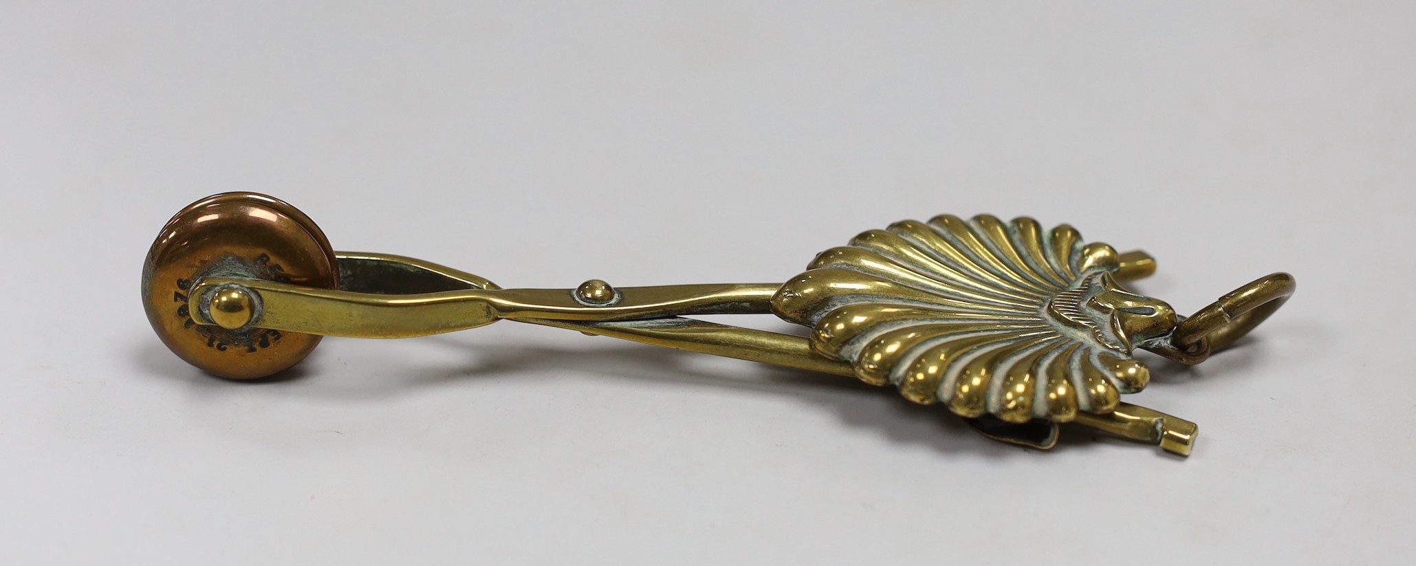 A brass skirt hem lifter. 14cm long